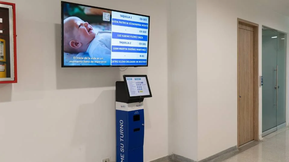 Point de service complet avec distributeur interactif au sol et moniteur suspendu pour orienter l'utilisateur